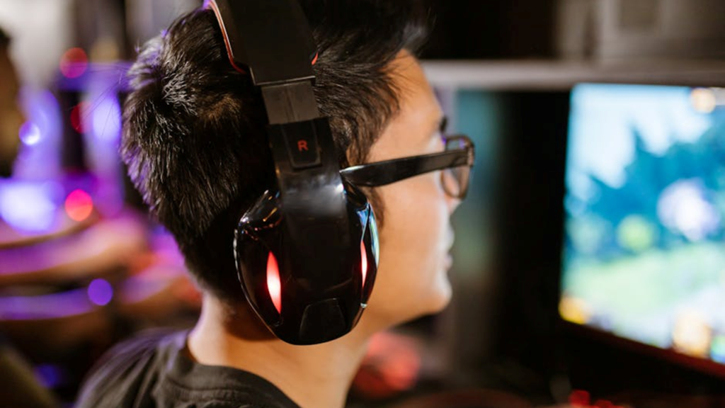 image of a video gamer in headphone; video gaming is a silent threat to hearing loss.